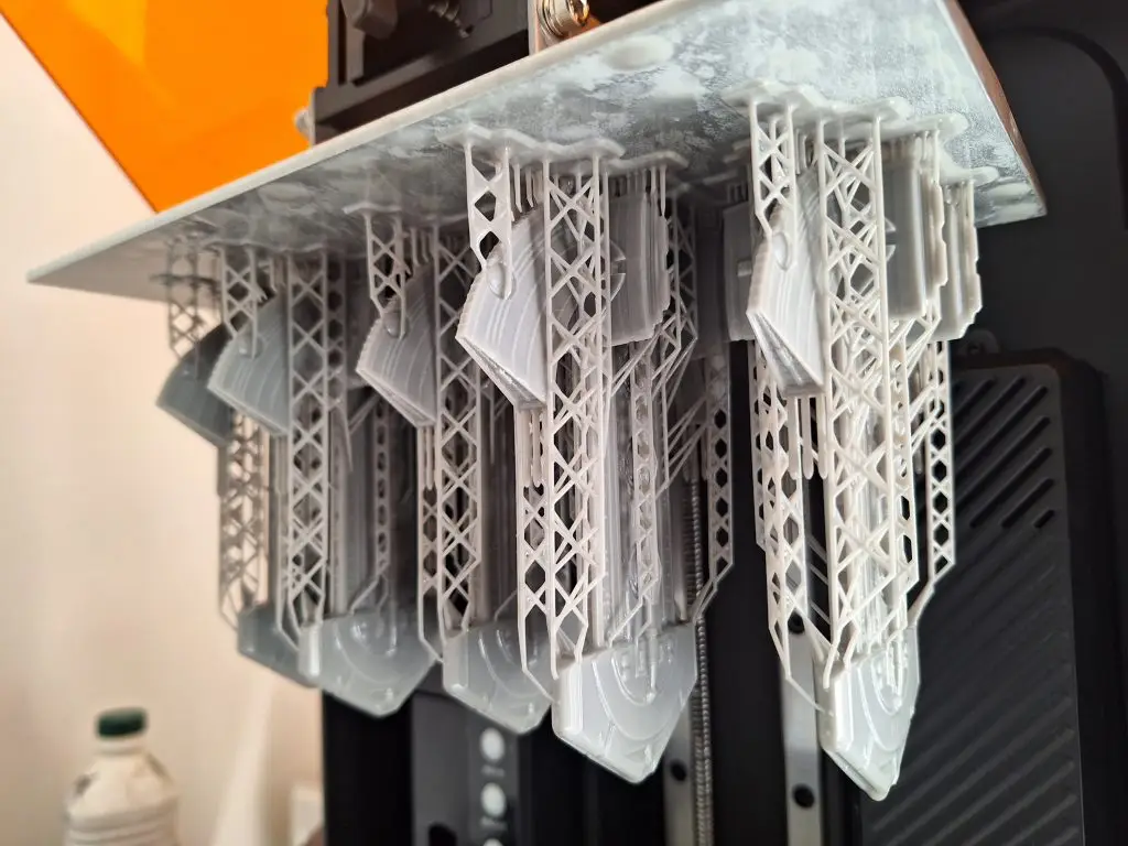 plateau impression d'une imprimante 3D résine avec pièces en résine et supports d'impression